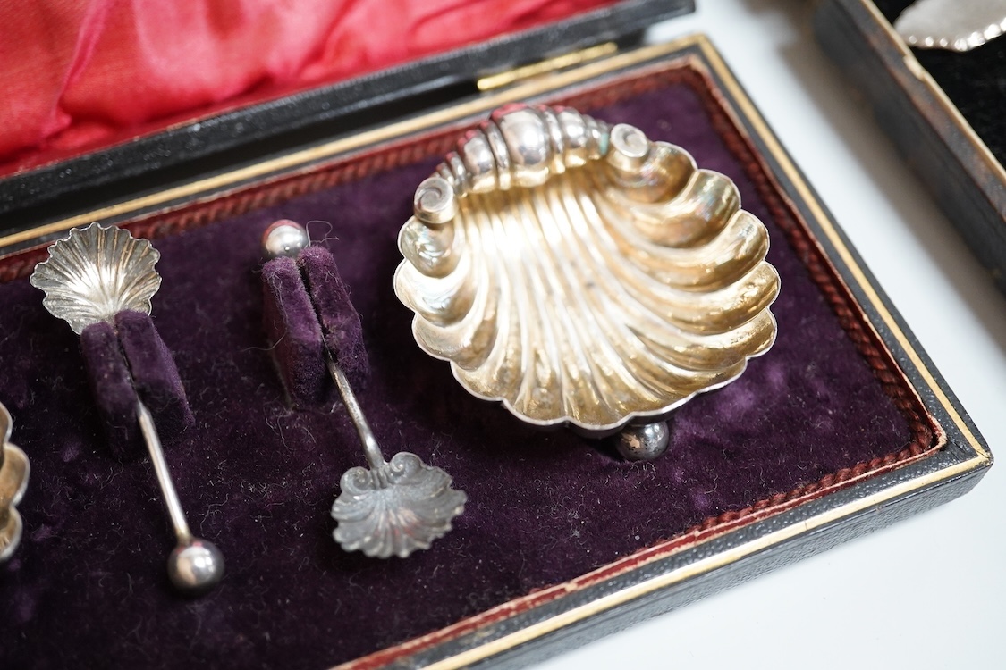 A cased pair of late Victorian silver shell salts on ball feet, with matching spoons, H. Bros, Birmingham, 1895, 46mm, together with a cased George V silver spoons and pusher and a Victorian silver shoe buckle (a.f.)